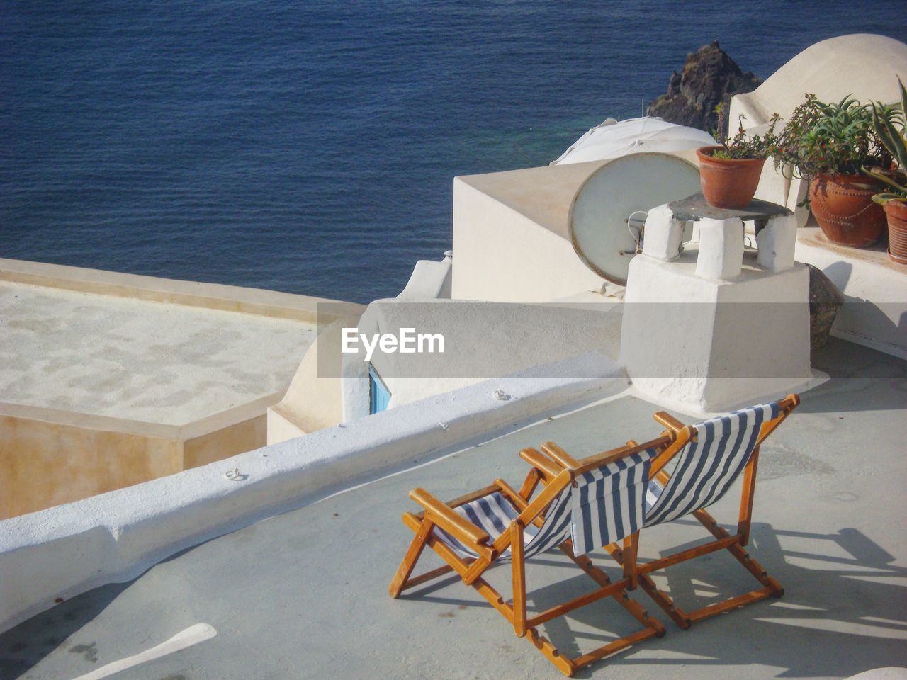 High angle view of deck chairs by sea