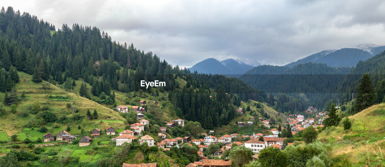 PANORAMIC VIEW OF TOWNSCAPE AGAINST MOUNTAINS