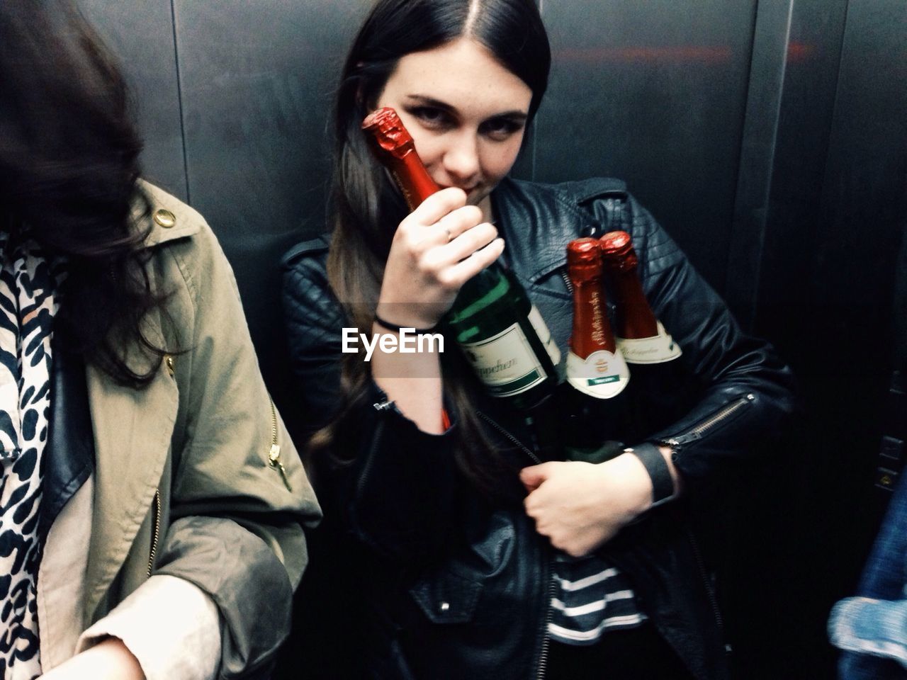 Portrait of a young woman with wine bottles