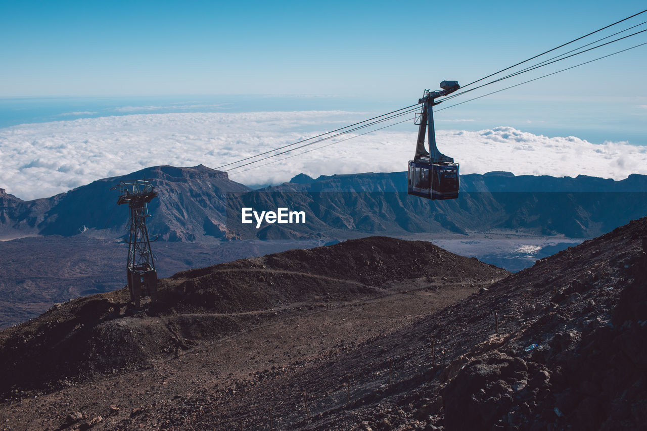 Overhead cable car on snowcapped mountains against sky