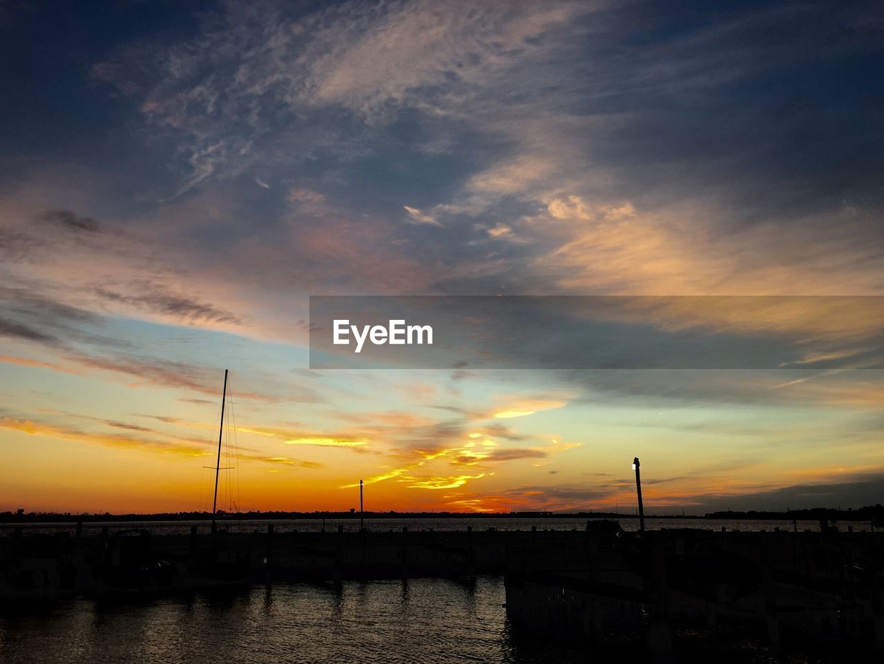 Scenic view of lake against orange sky at sunset