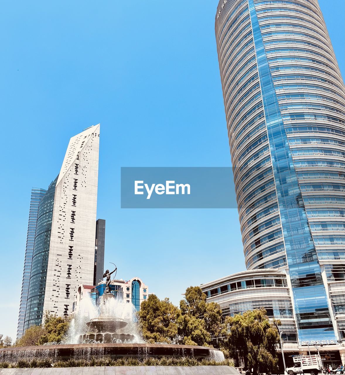 low angle view of modern buildings against clear blue sky