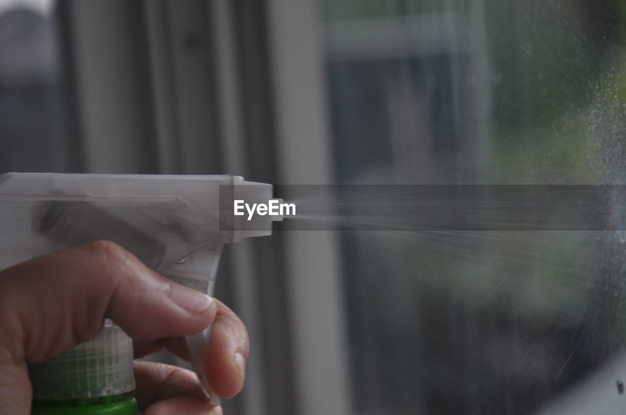 Close-up of person spraying disinfectant