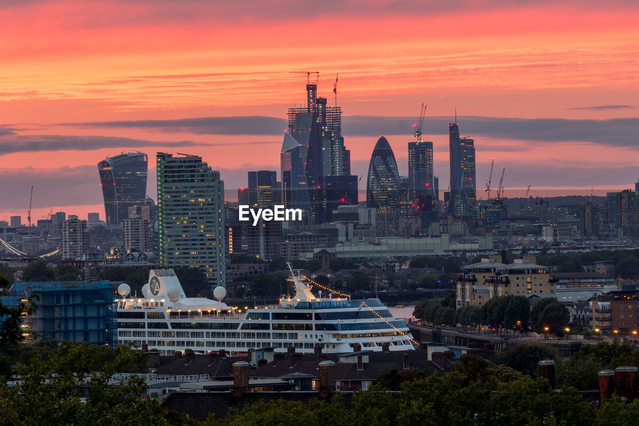 BUILDINGS IN CITY AGAINST ORANGE SKY