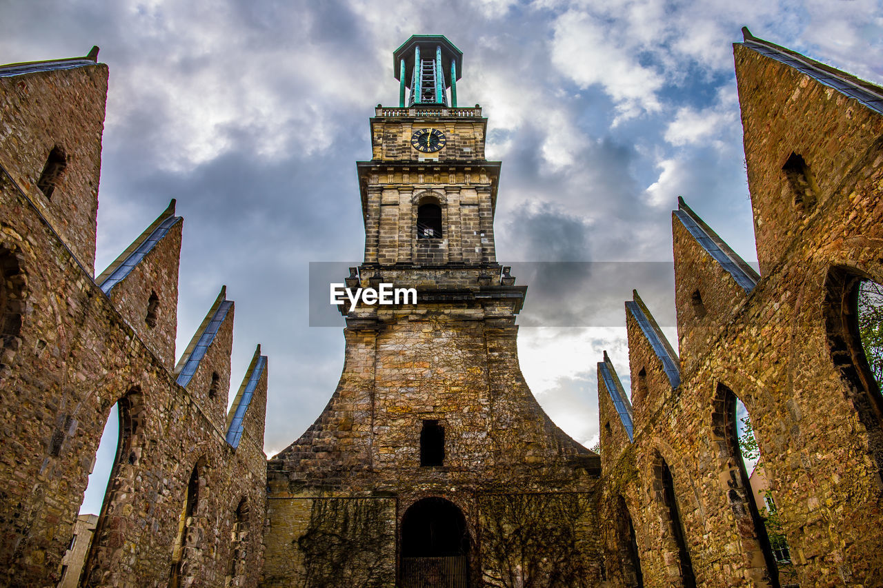 Low angle view of clock tower against cloudy sky