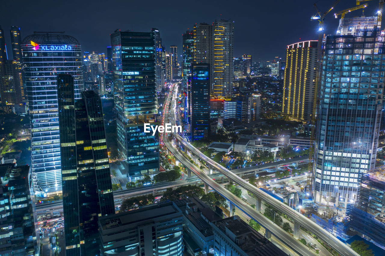 AERIAL VIEW OF ILLUMINATED BUILDINGS AT NIGHT