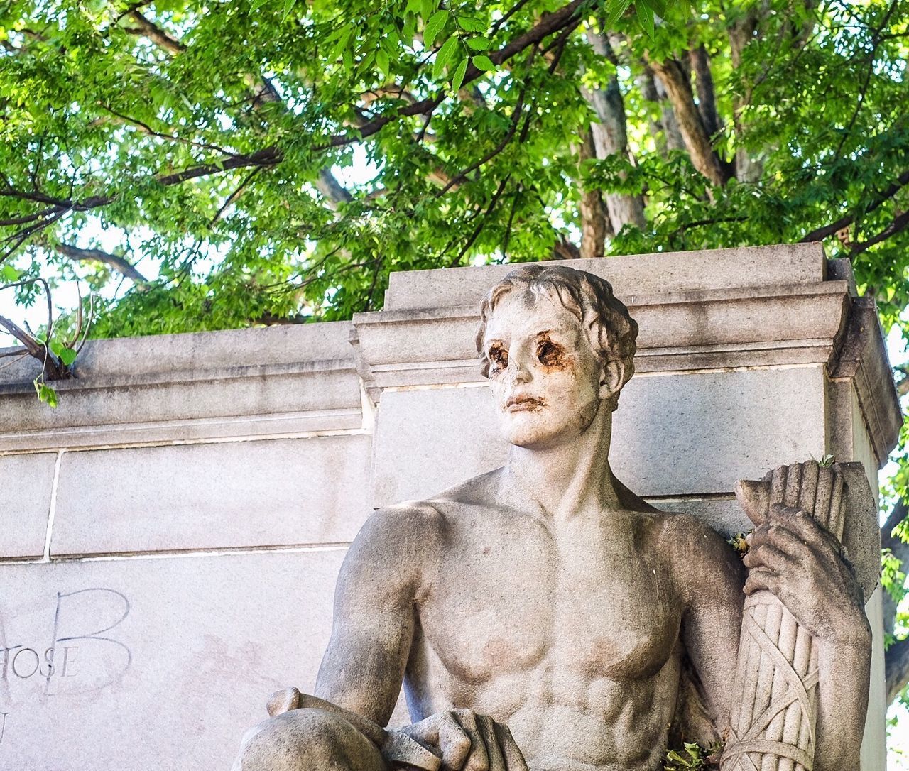 Low angle view of old statue against tree