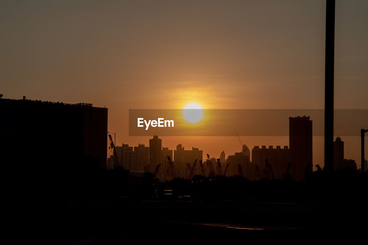 Silhouette buildings against sky during sunset