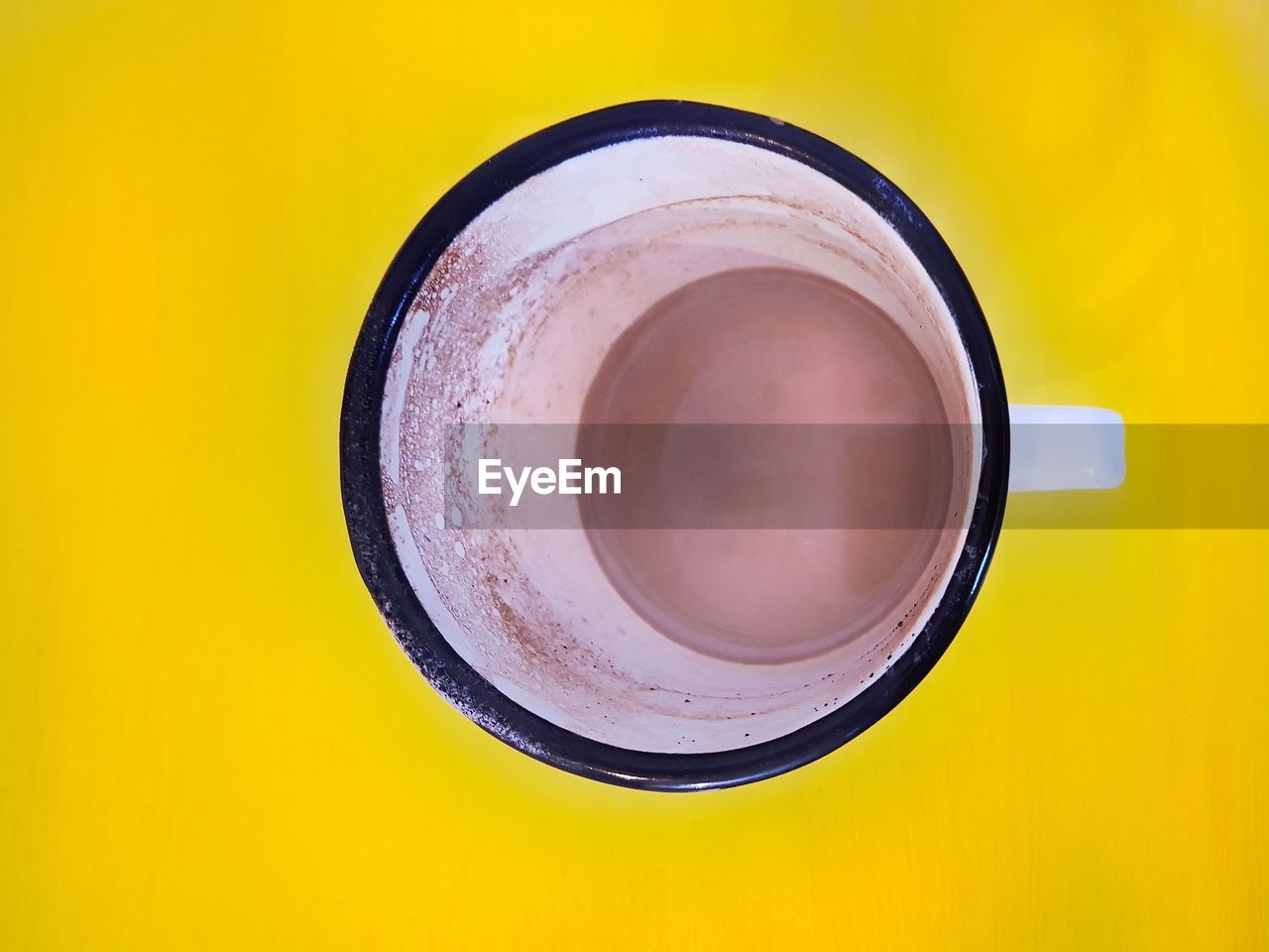 DIRECTLY ABOVE SHOT OF TEA CUP ON YELLOW TABLE