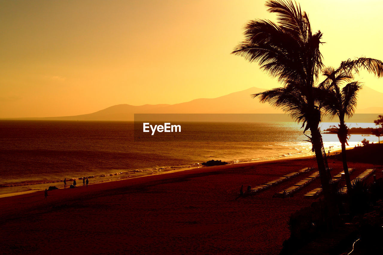 Scenic view of sea and beach against sky during sunset