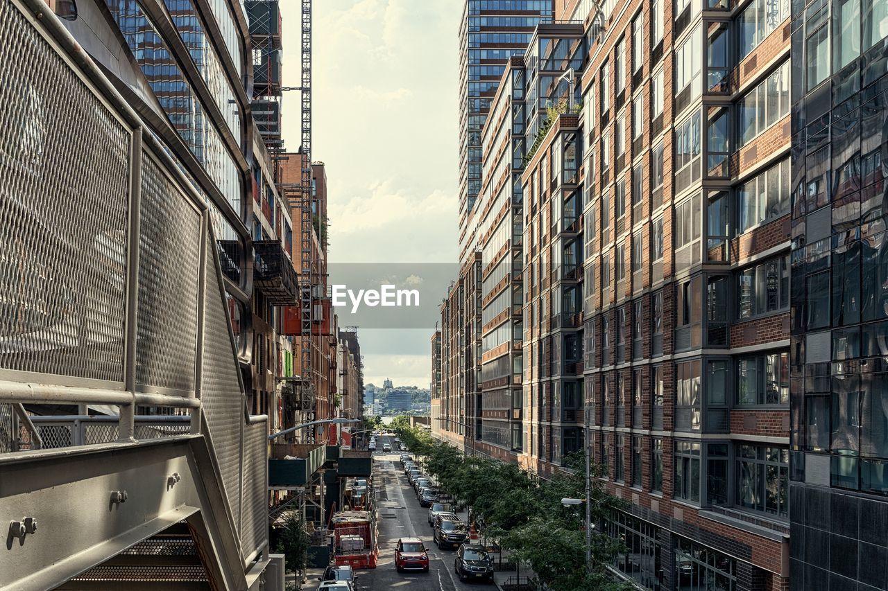 Cars on road amidst buildings in city against sky