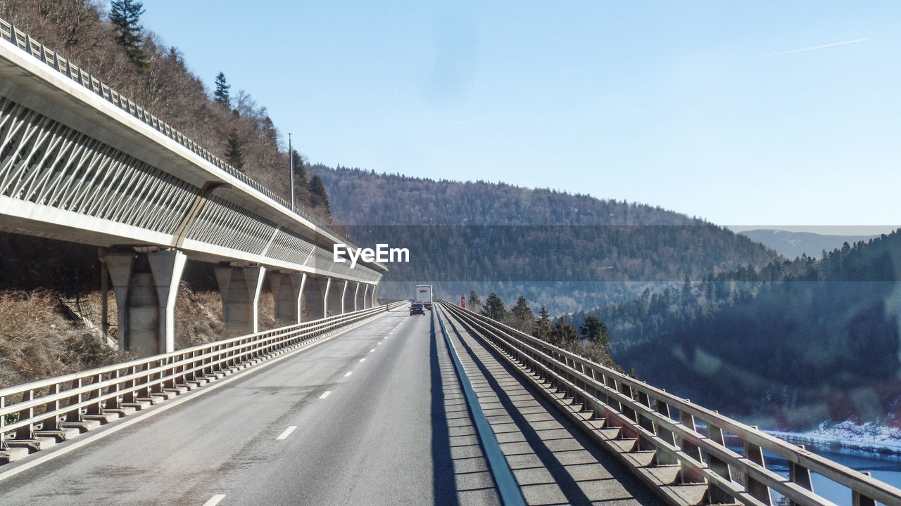 VIEW OF RAILROAD TRACKS BY ROAD AGAINST SKY