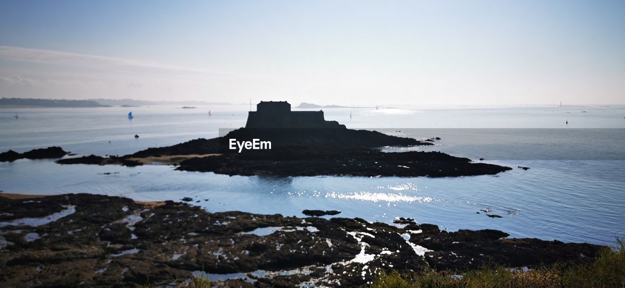 SCENIC VIEW OF ROCKS ON SHORE AGAINST SKY