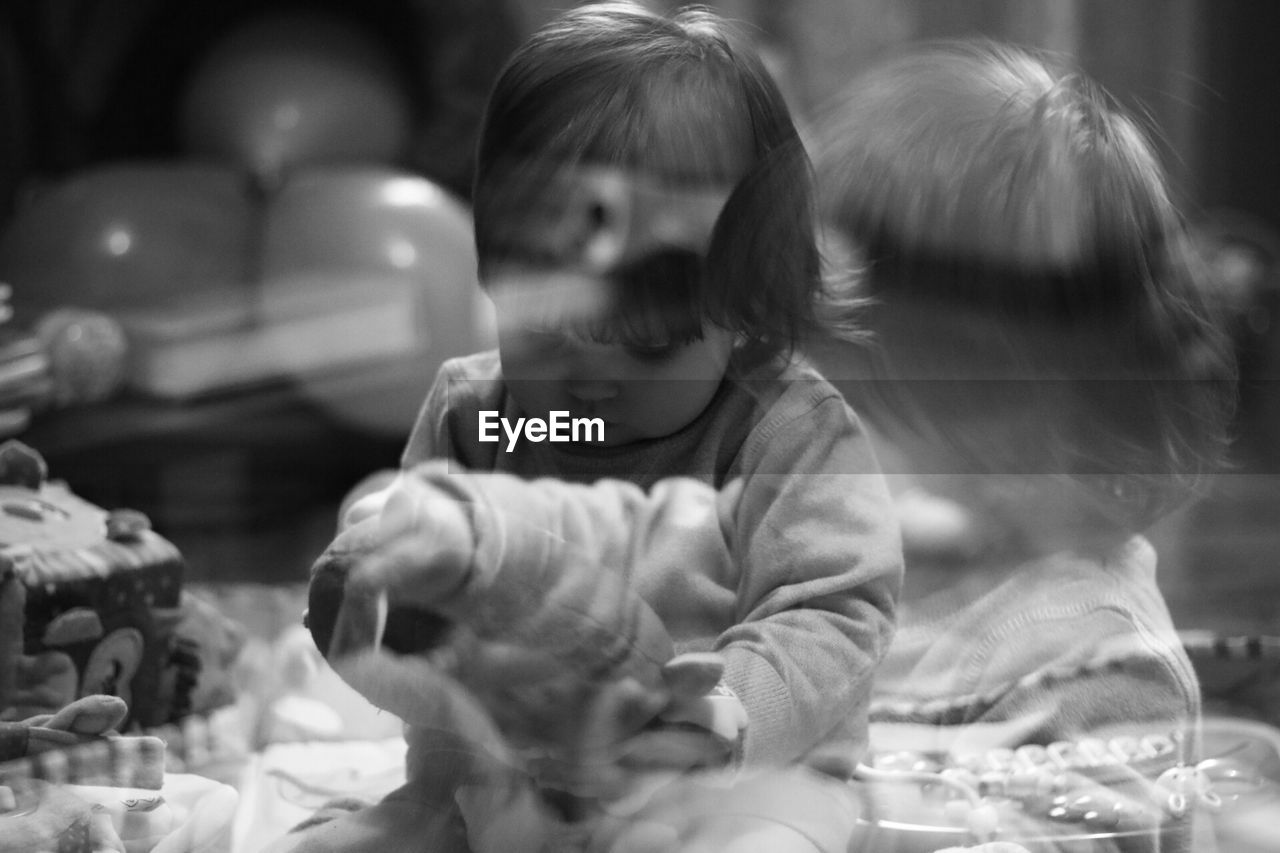 Multiple exposure image of baby girl playing at home