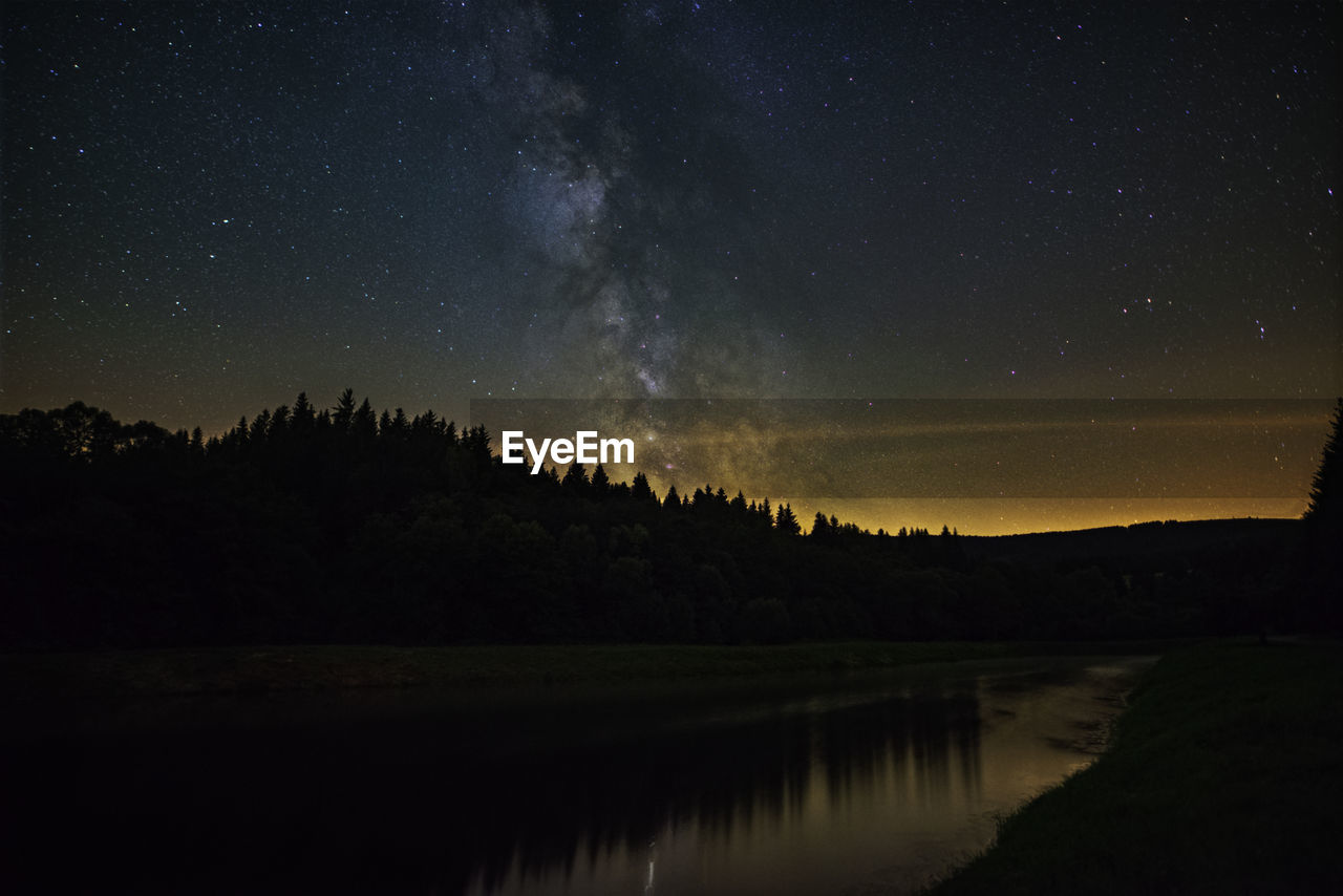 Scenic view of lake against sky at night