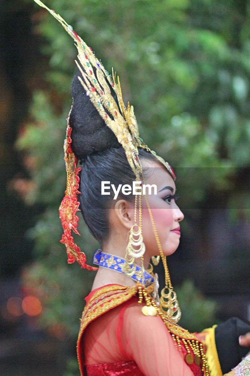Side view of young woman wearing headdress during festival