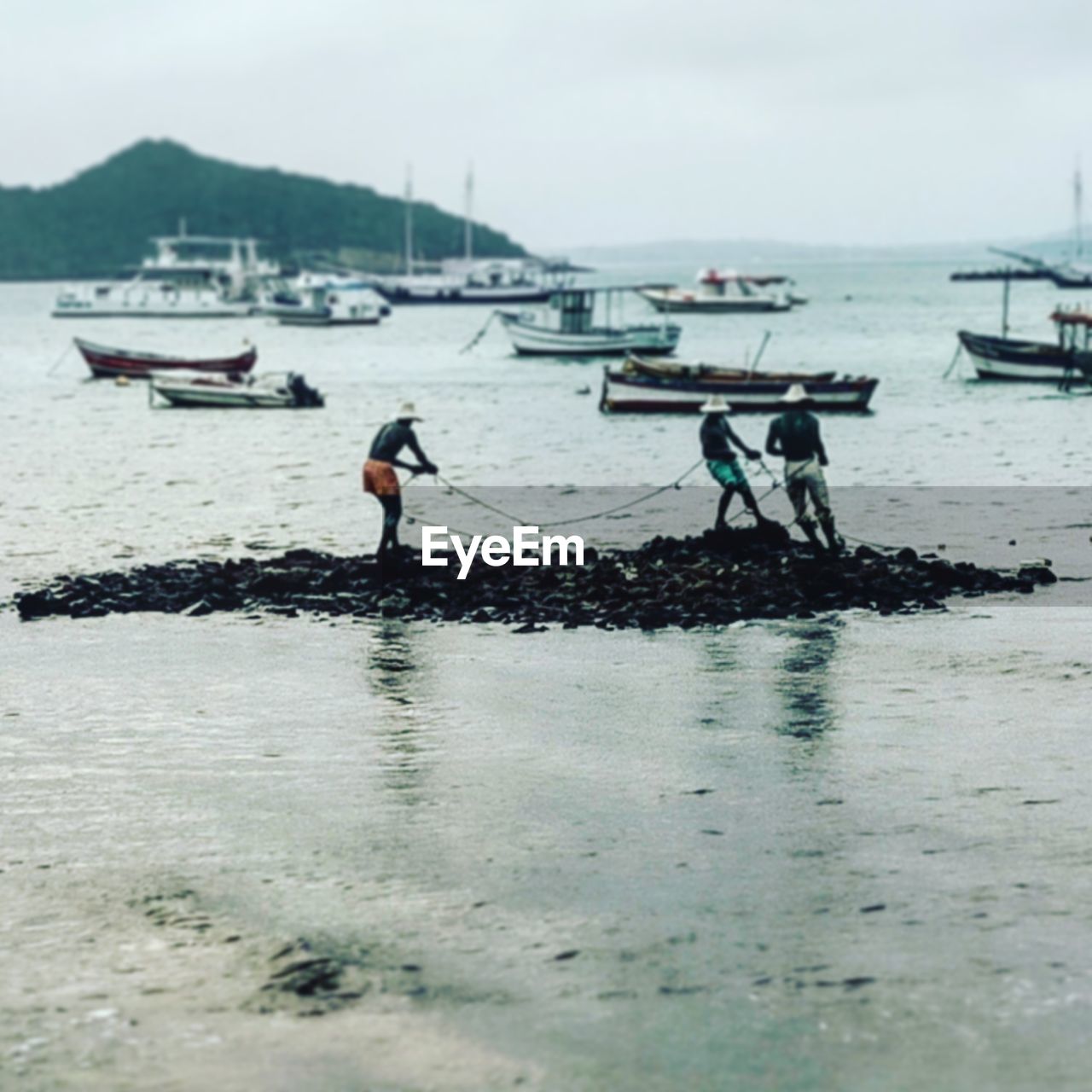 People working at beach against sky