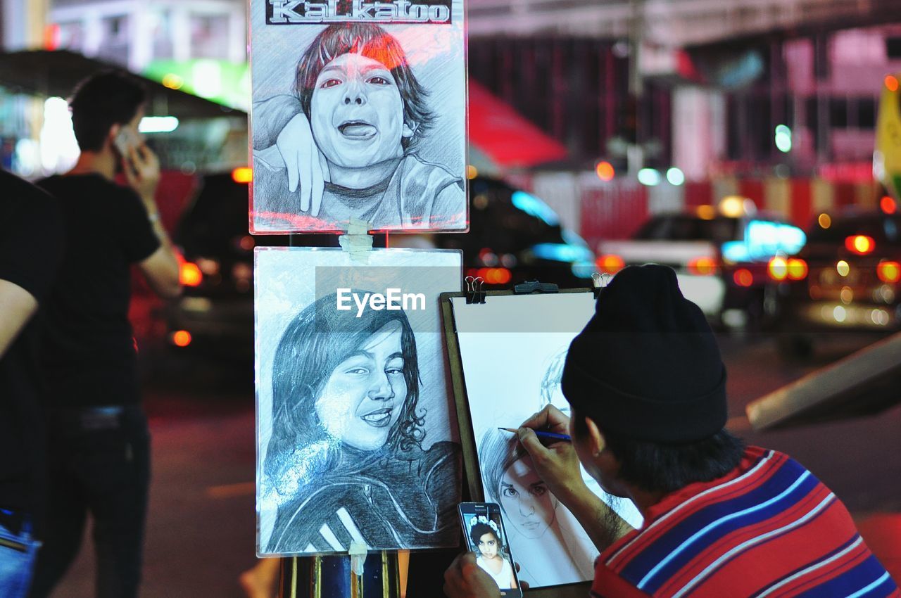 Rear view of woman making sketches on paper