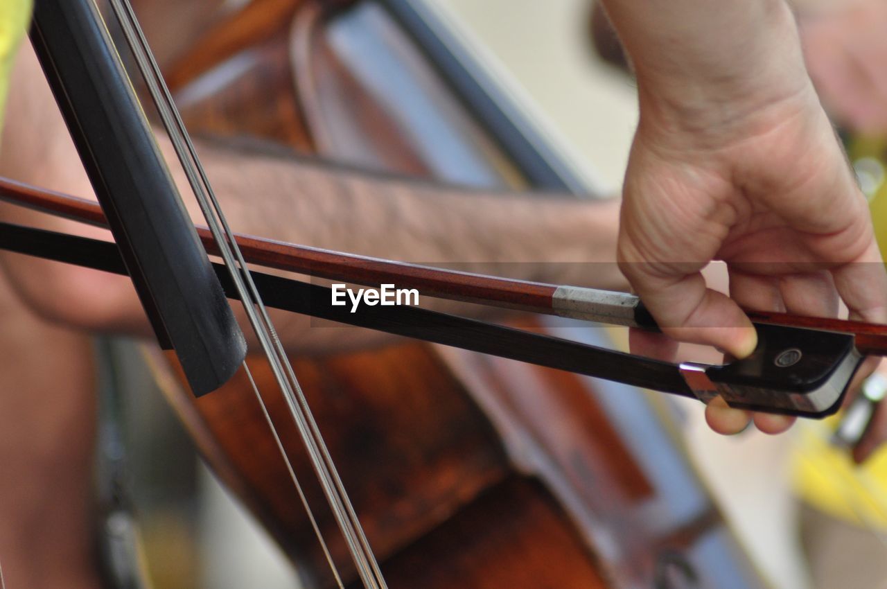 Cropped hands of man playing musical instrument