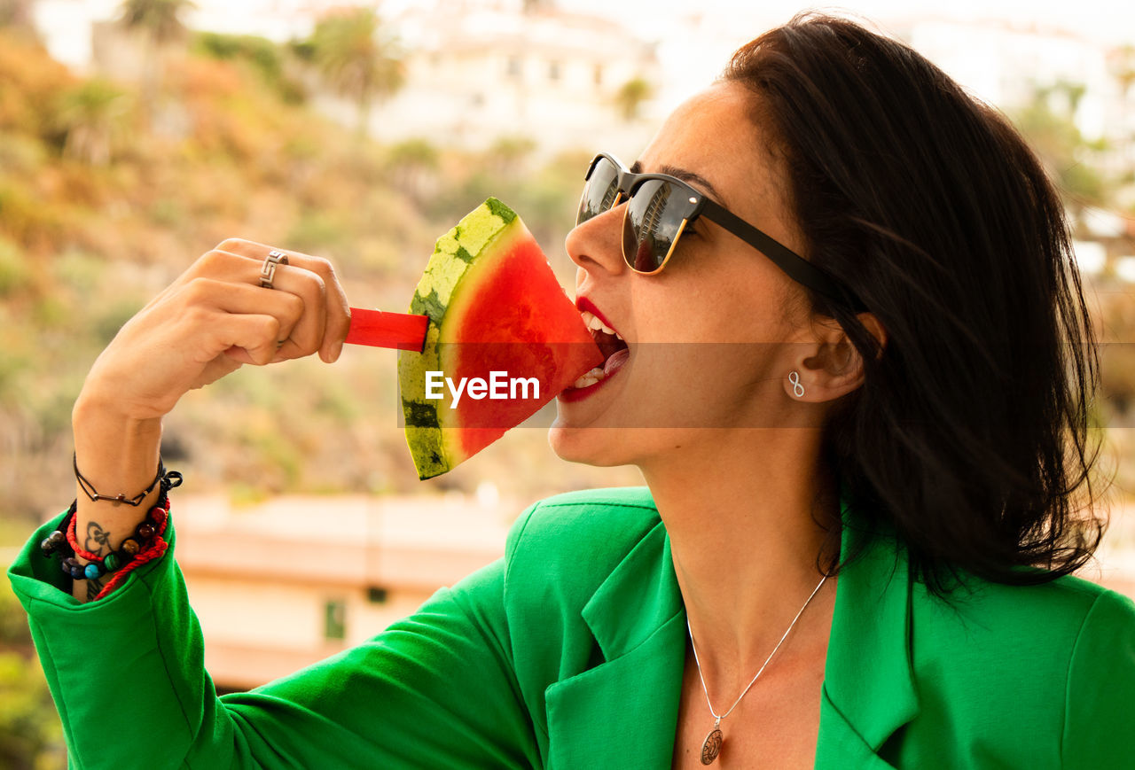 Side view of woman eating watermelon