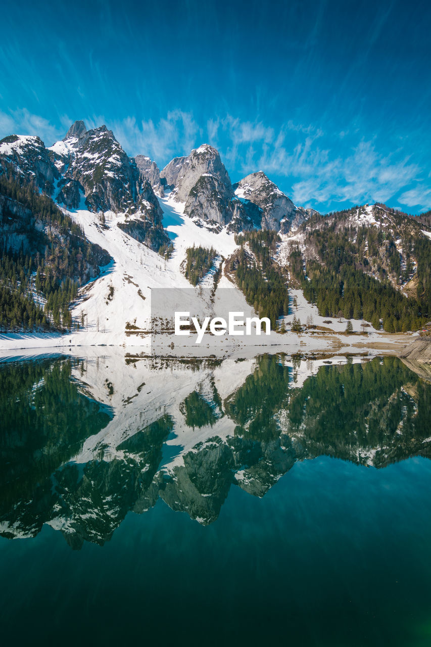 Aerial view of lake by snowcapped mountain against sky