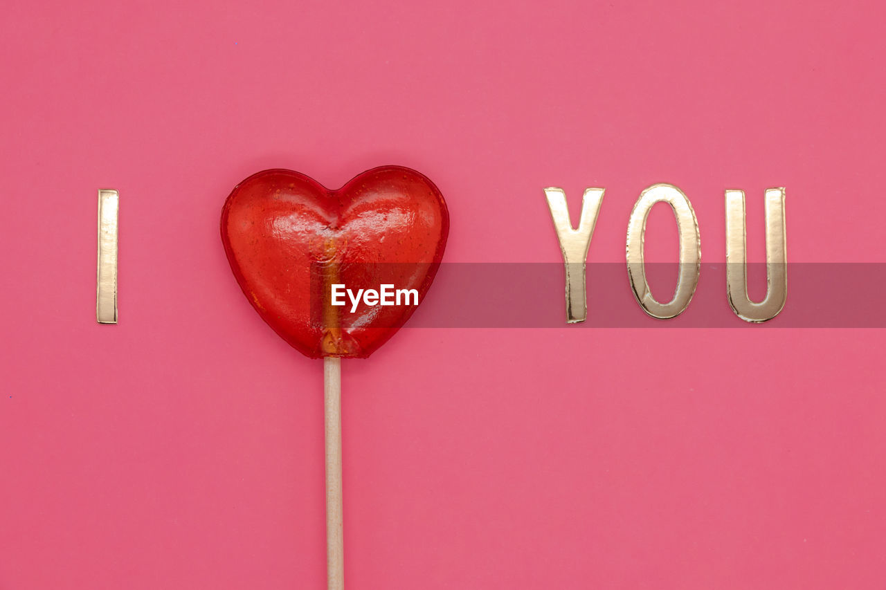 CLOSE-UP OF HEART SHAPE MADE ON PINK RED BACKGROUND