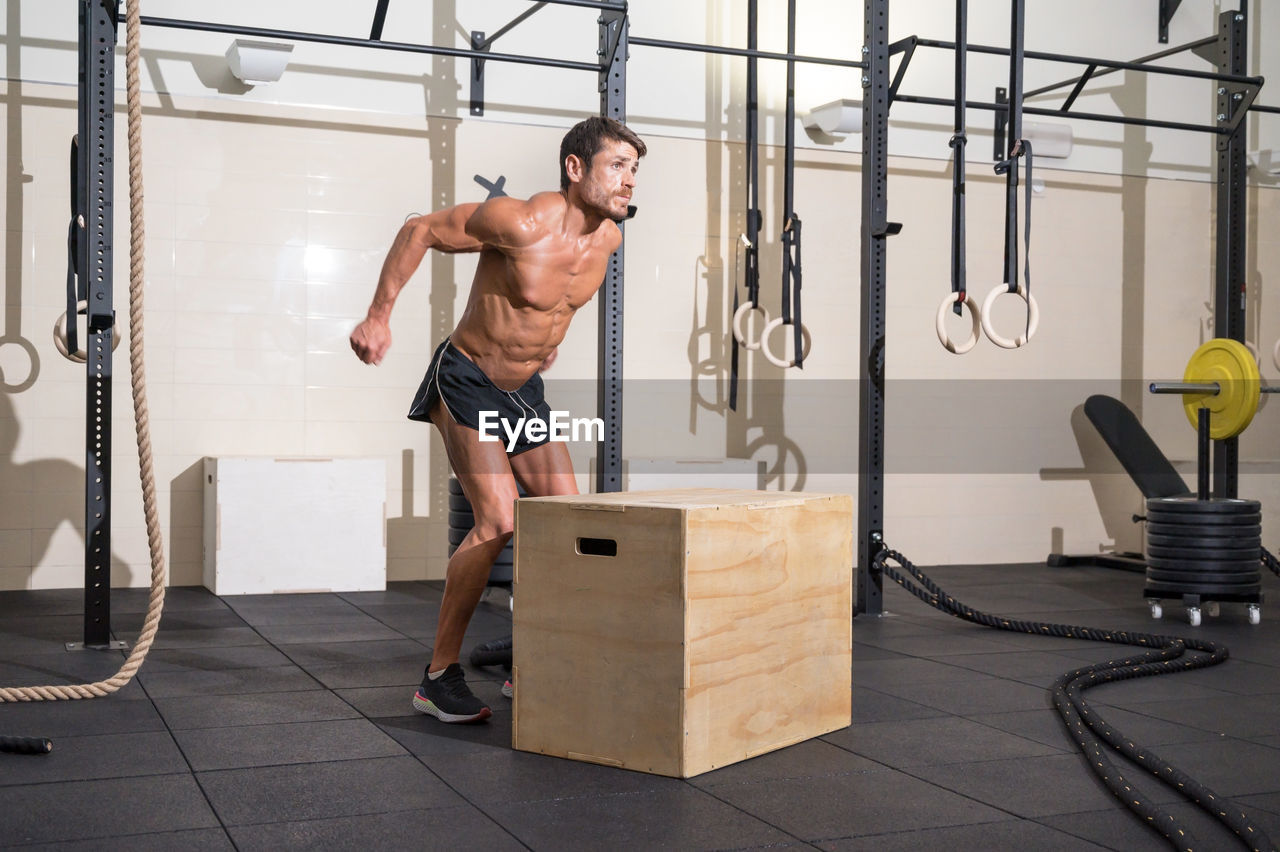 Shirtless man exercising at gym