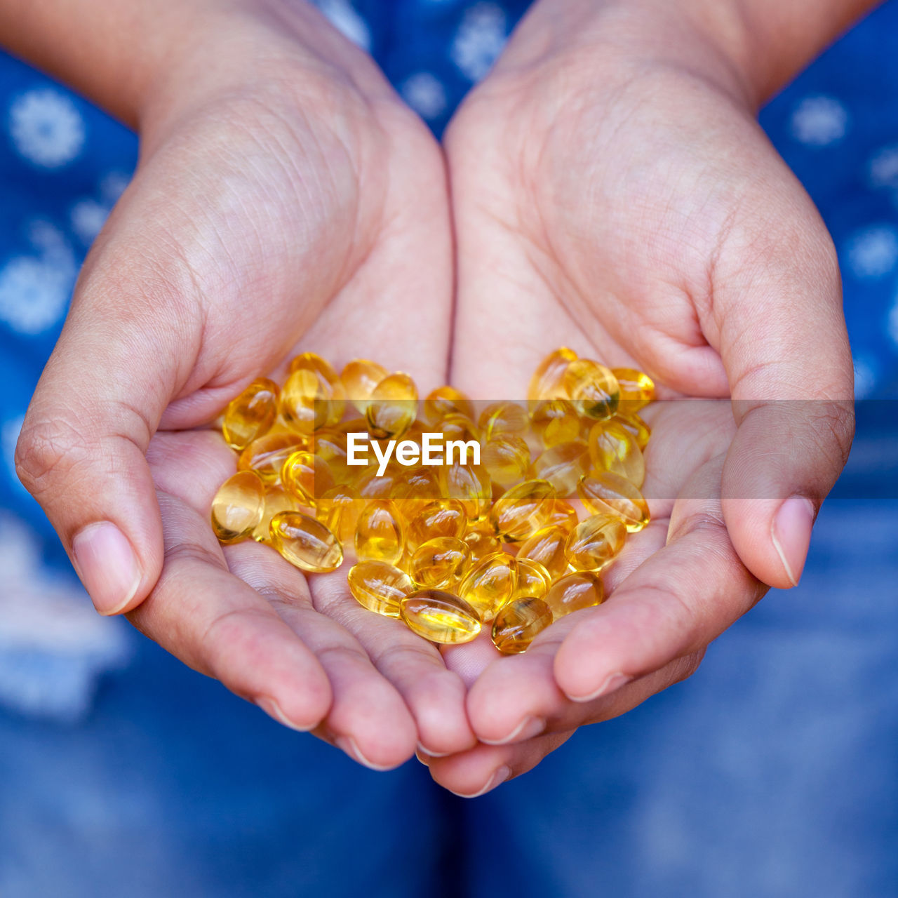 Close-up of woman hands holding cod pills