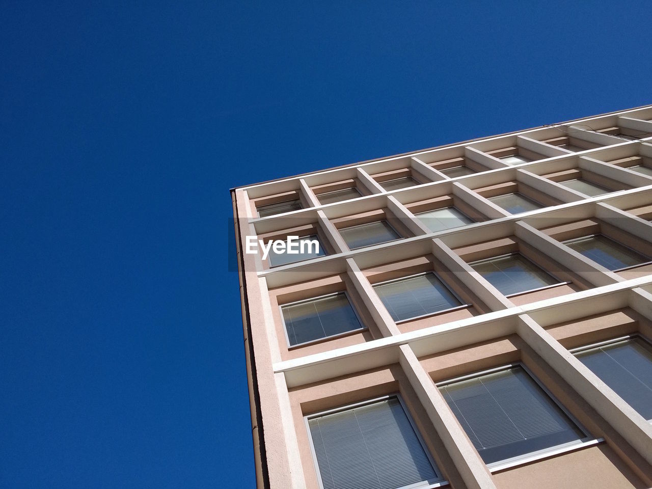 Low angle view of modern building against clear blue sky