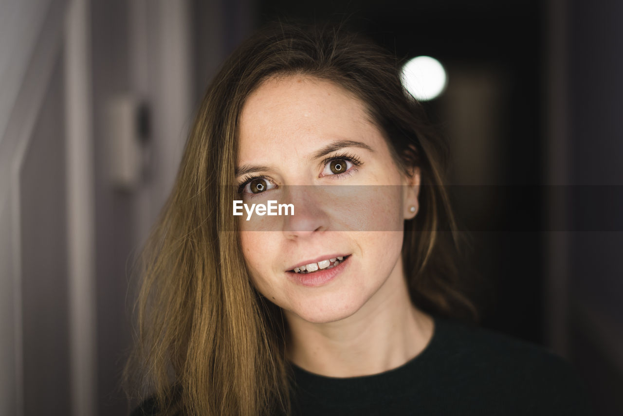 Close-up portrait of smiling woman at home