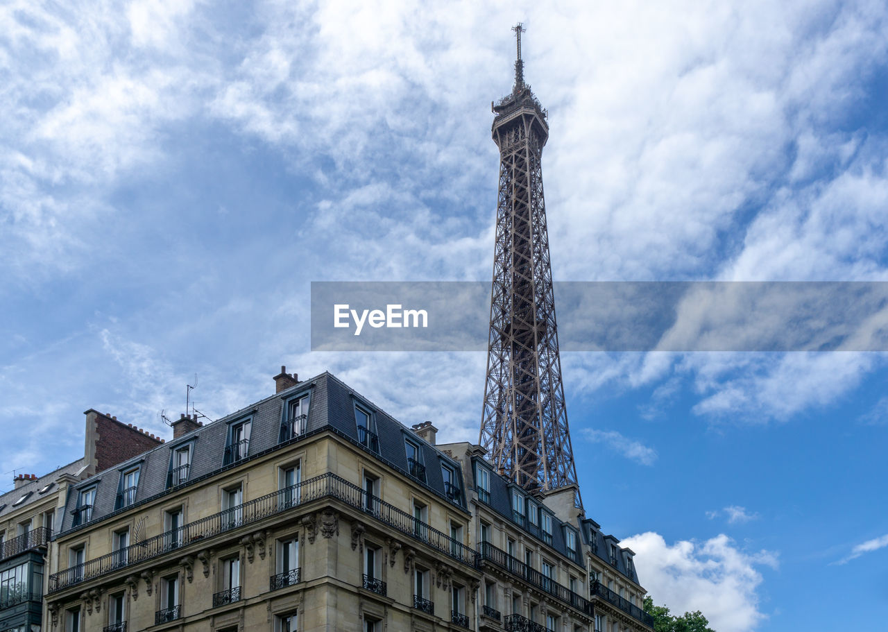 LOW ANGLE VIEW OF BUILDINGS IN CITY AGAINST CLOUDY SKY