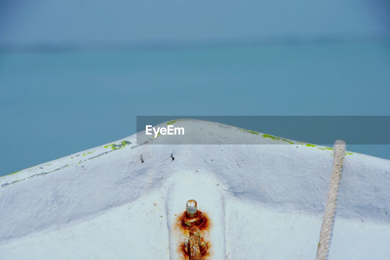 CLOSE-UP OF ROPE AGAINST BLUE SEA