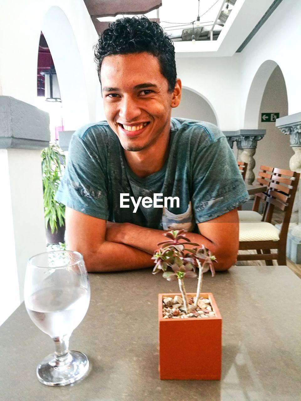 Portrait of smiling young man sitting at table in restaurant