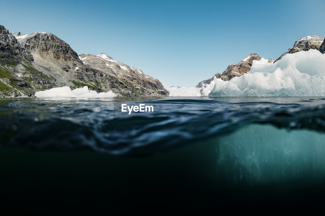 Surface level of frozen sea against clear blue sky