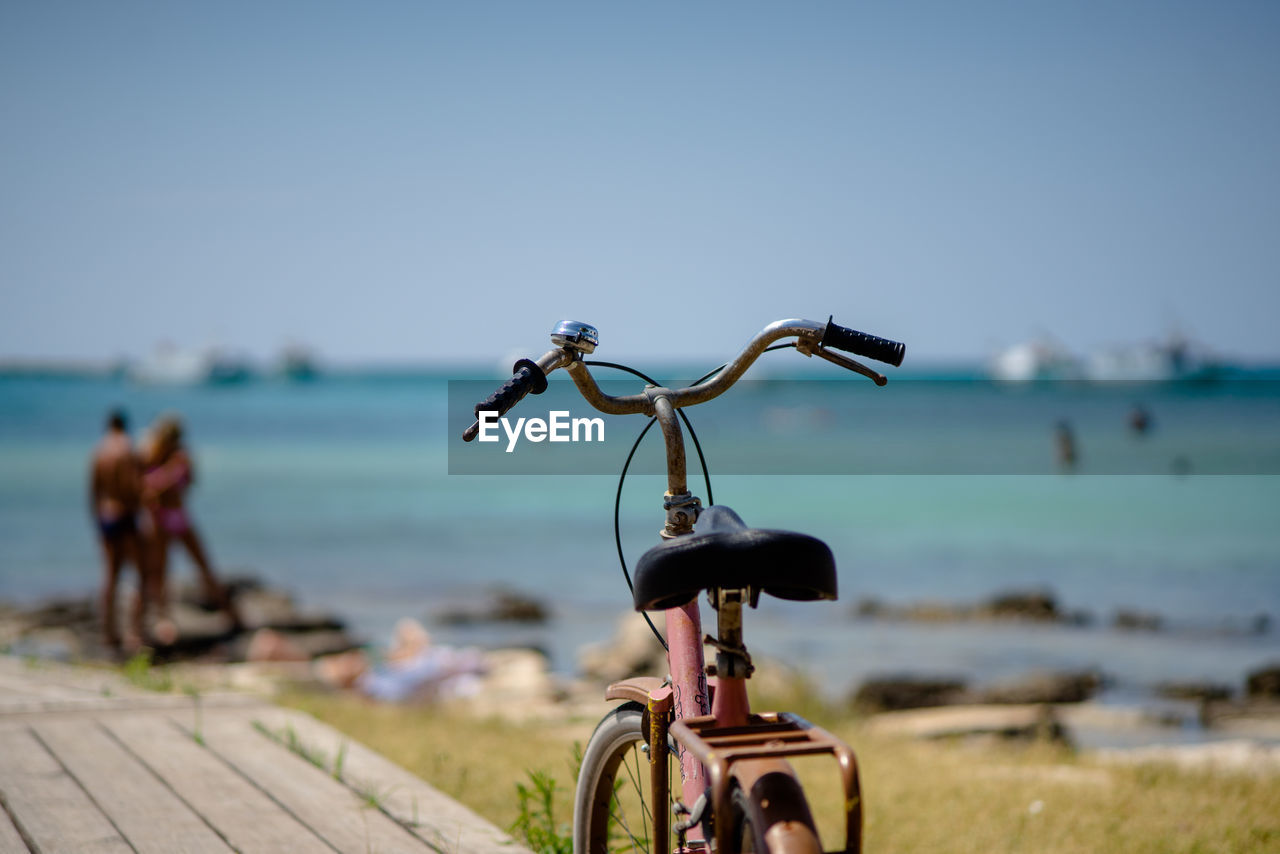 Bicycle on beach against sky