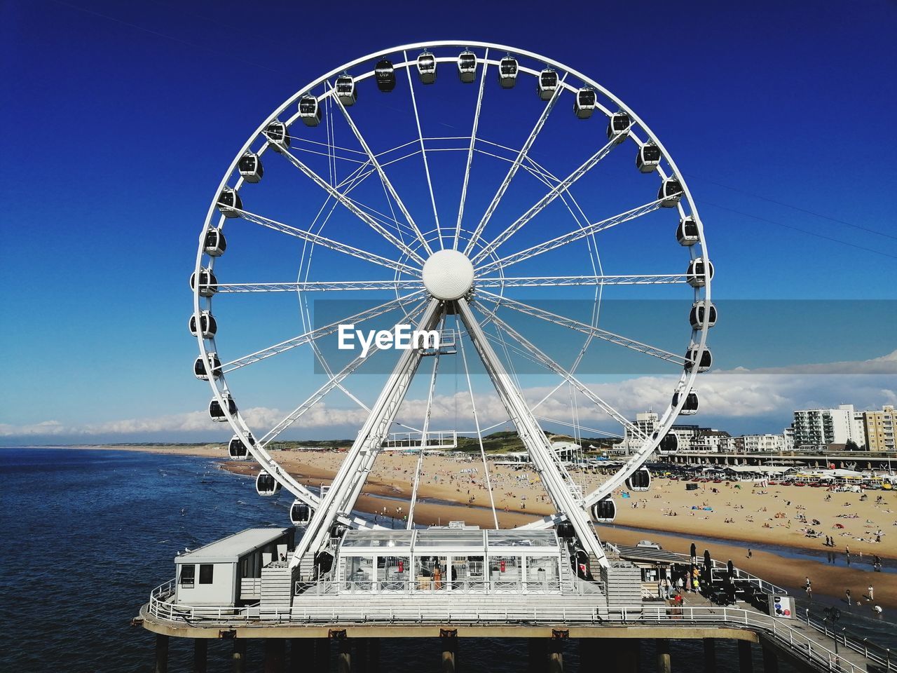 Ferris wheel in city against blue sky