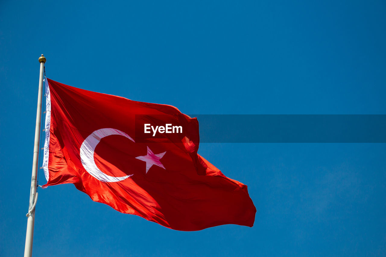 LOW ANGLE VIEW OF FLAG FLAGS AGAINST BLUE SKY