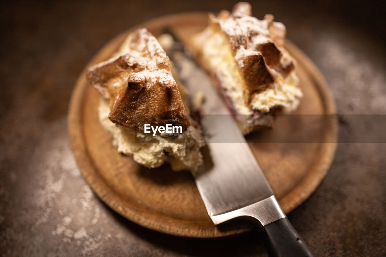 Close-up of dessert in plate cut on table with knife