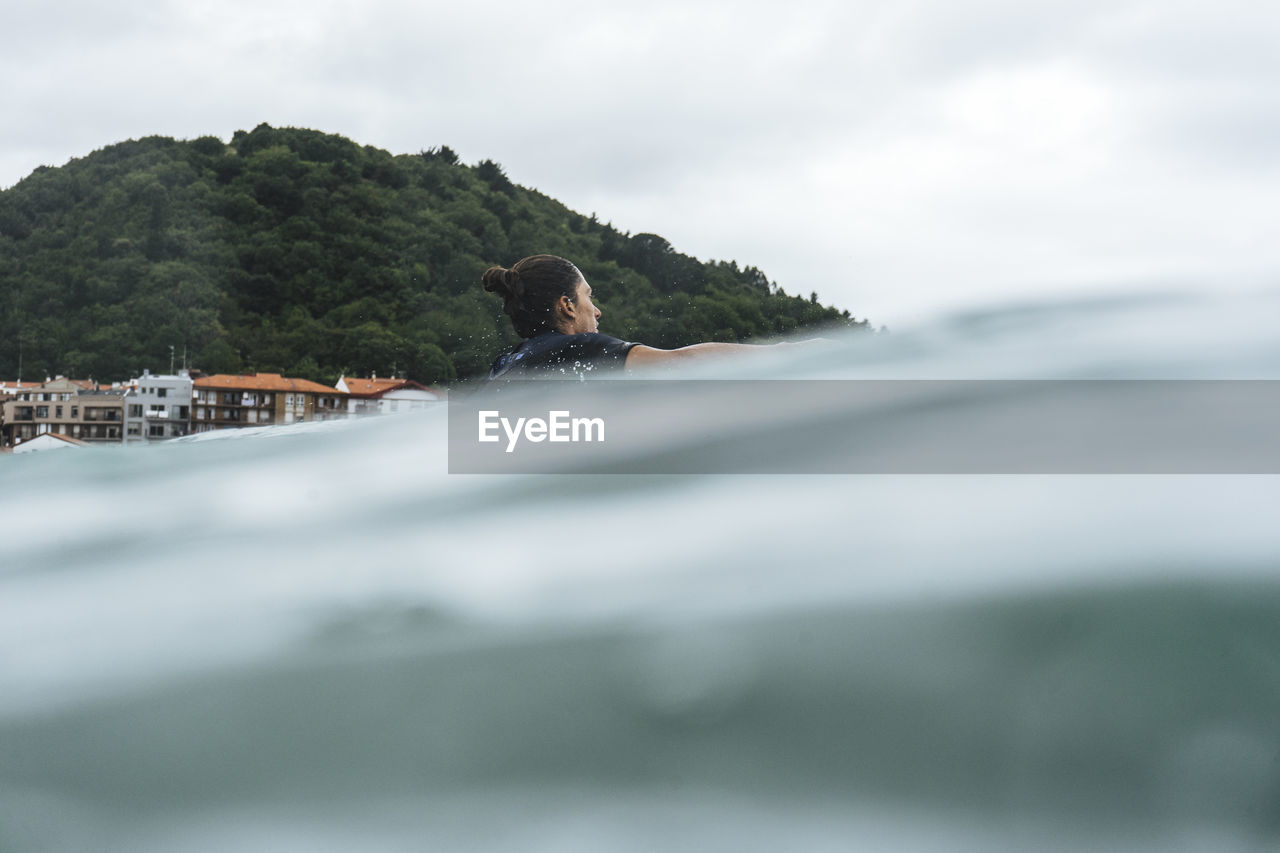 Surfer entering the water in basque country, spain, bilbao