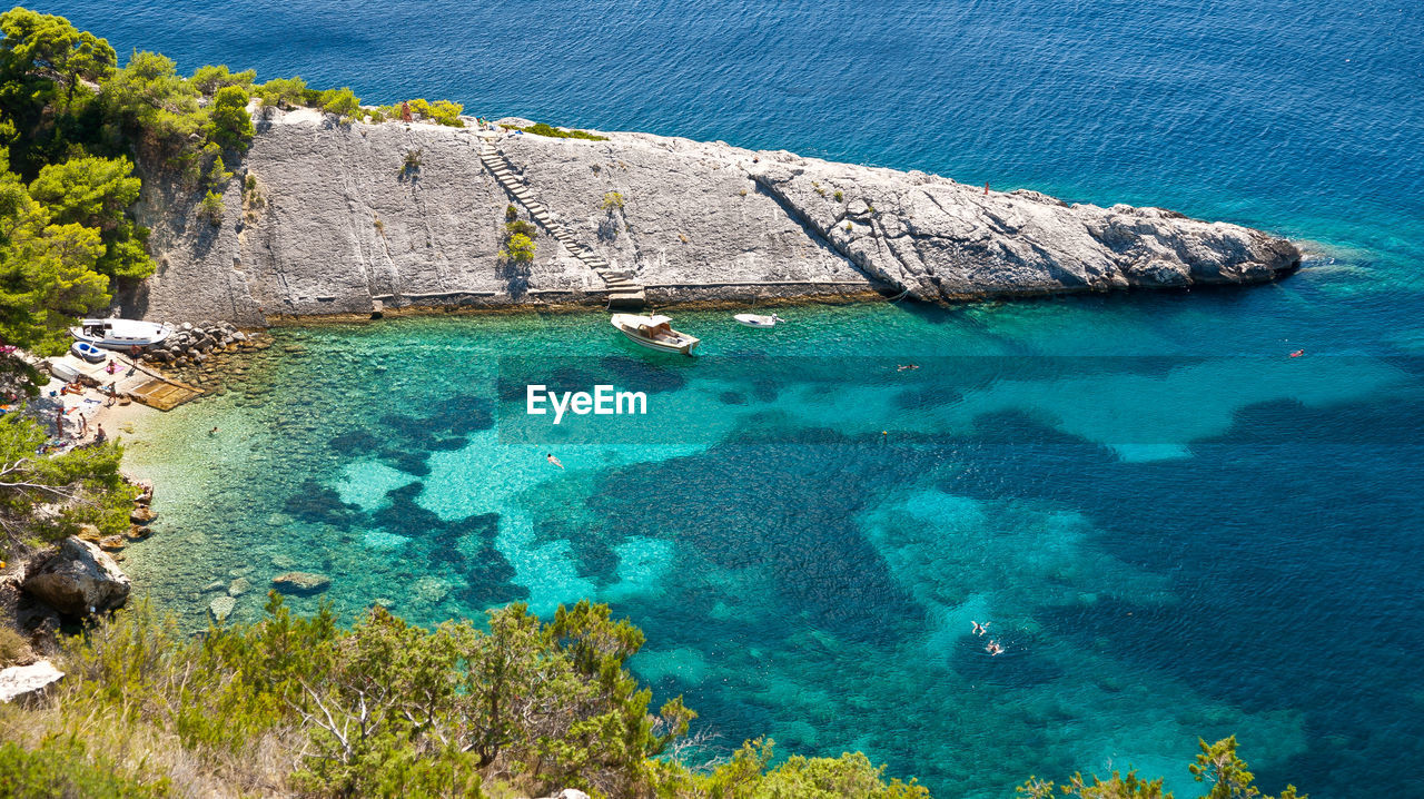 HIGH ANGLE VIEW OF ROCKS ON SHORE AT BEACH