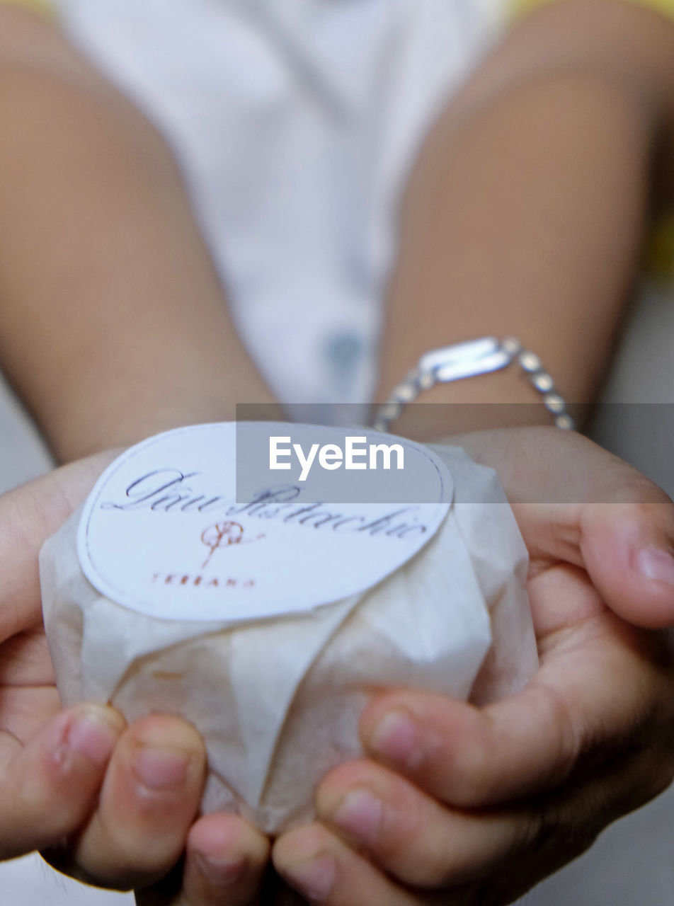 CLOSE-UP OF WOMAN HOLDING HANDS WITH TEXT ON WHITE BACKGROUND