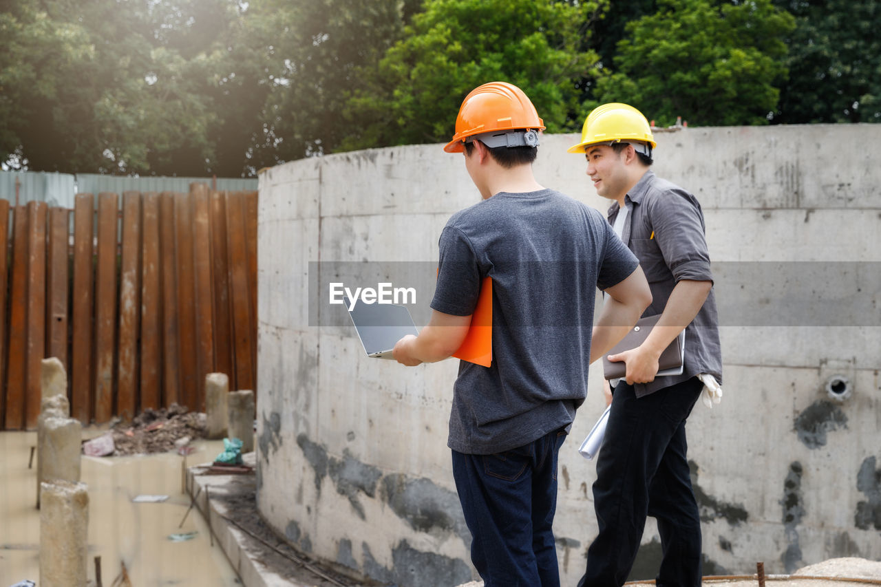 Architects walking by wall at site