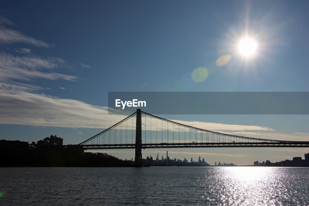 Suspension bridge over river against sky