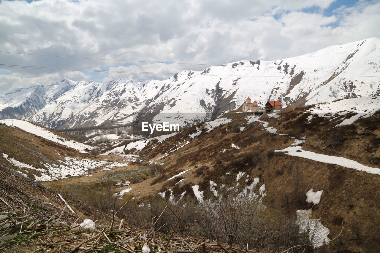 SCENIC VIEW OF SNOW COVERED MOUNTAINS AGAINST SKY