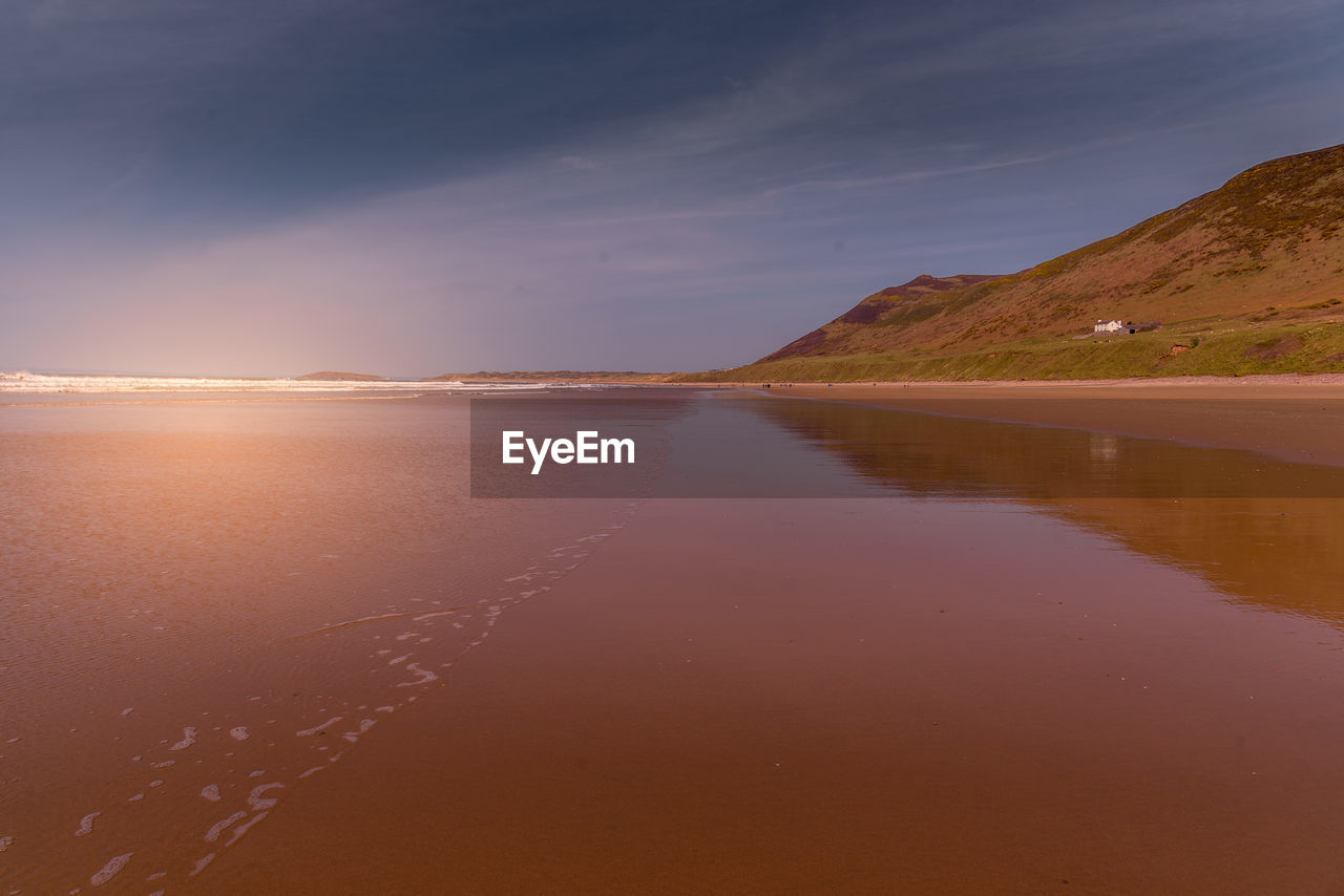 Scenic view of beach against sky during sunset