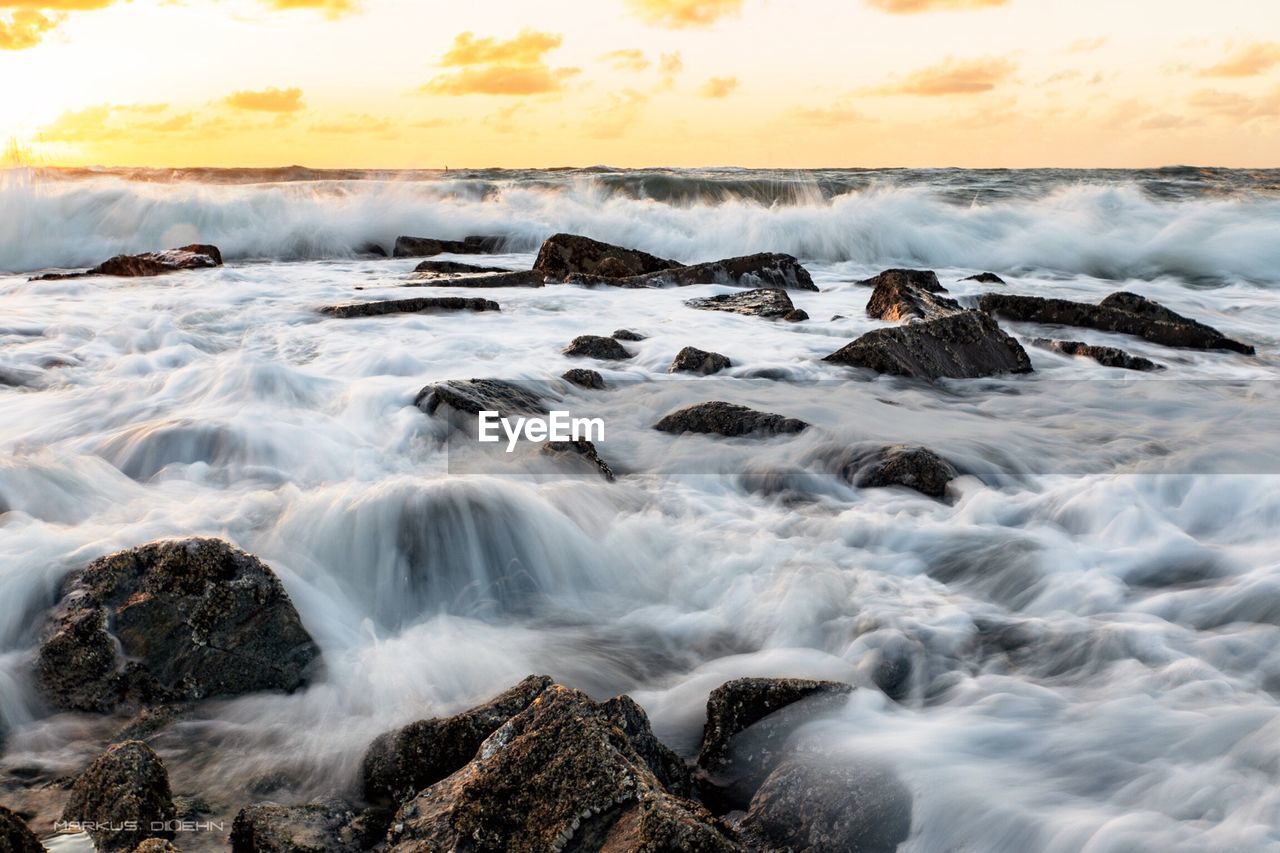 Blurred motion of waves splashing on rocks at shore