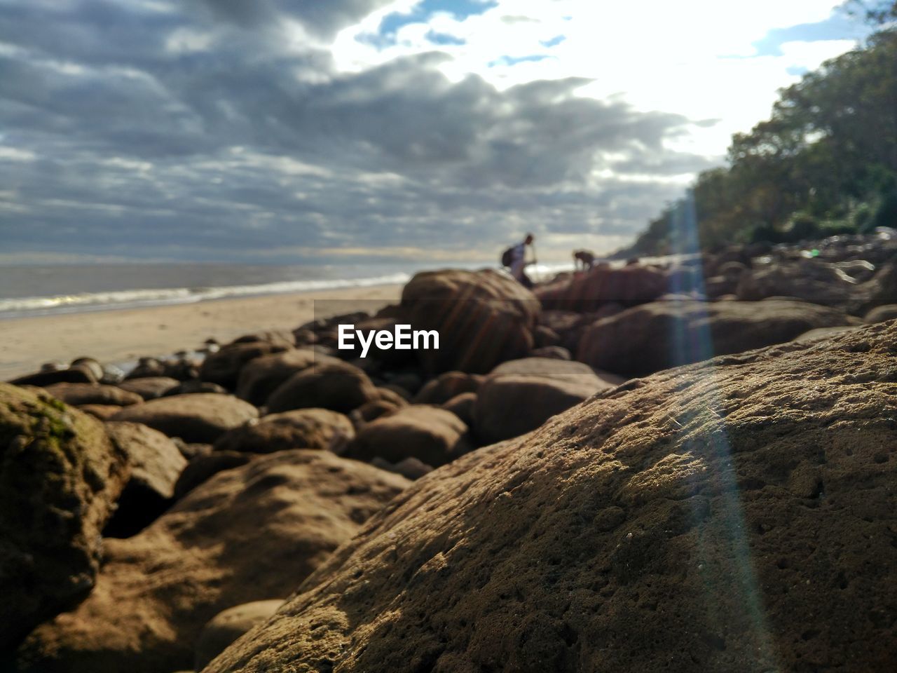 ROCKS AT SHORE AGAINST SKY