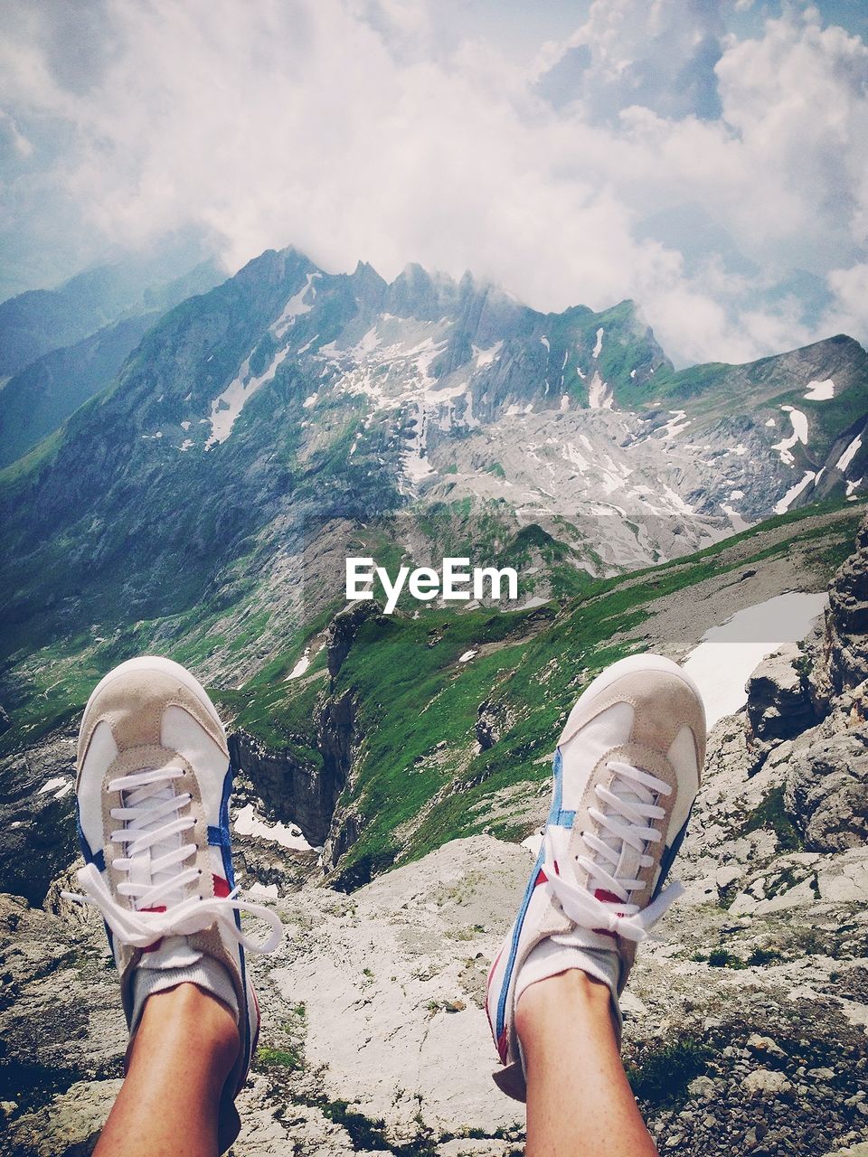 WOMAN STANDING ON MOUNTAIN LANDSCAPE