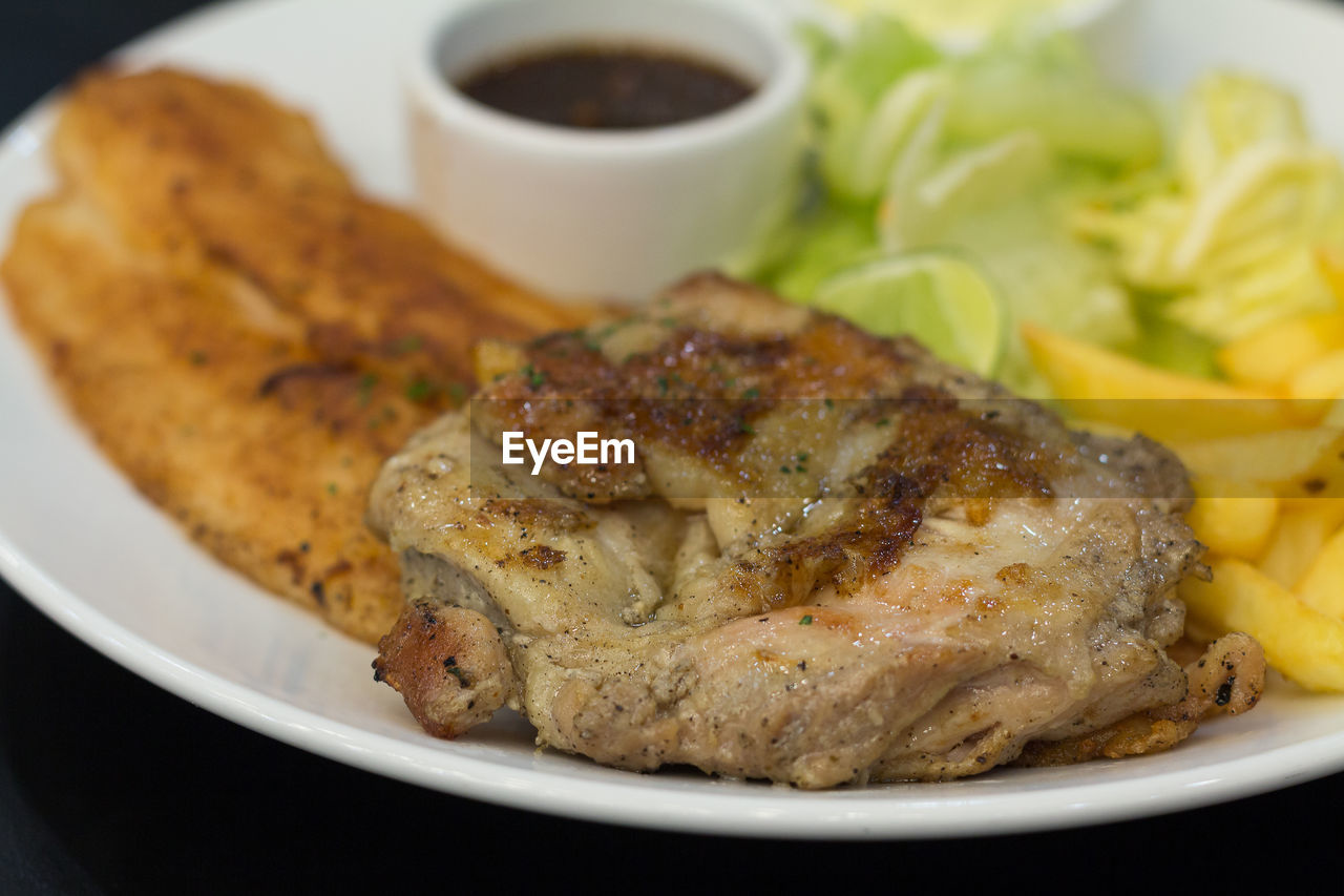 CLOSE-UP OF MEAT WITH BREAD IN PLATE