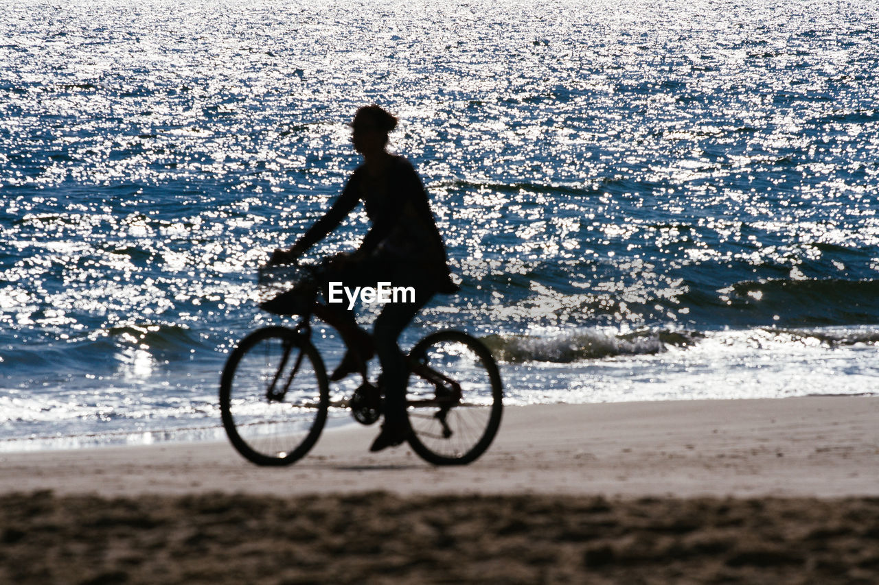 Woman riding bicycle at beach